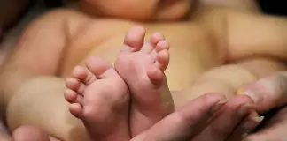barefoot baby in his mother's hands